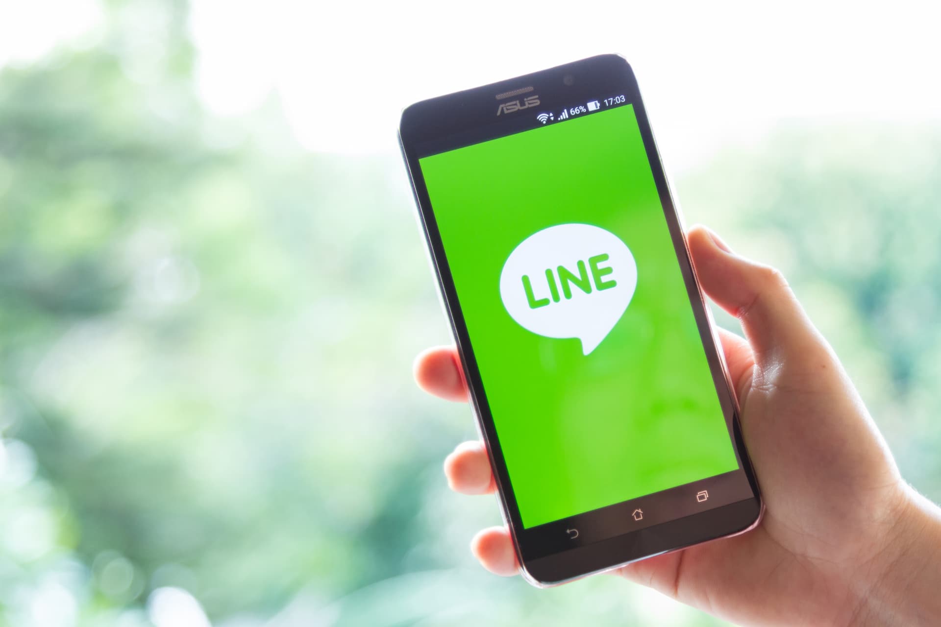 LINEアプリの画面が表示されたスマートフォンを持つ手